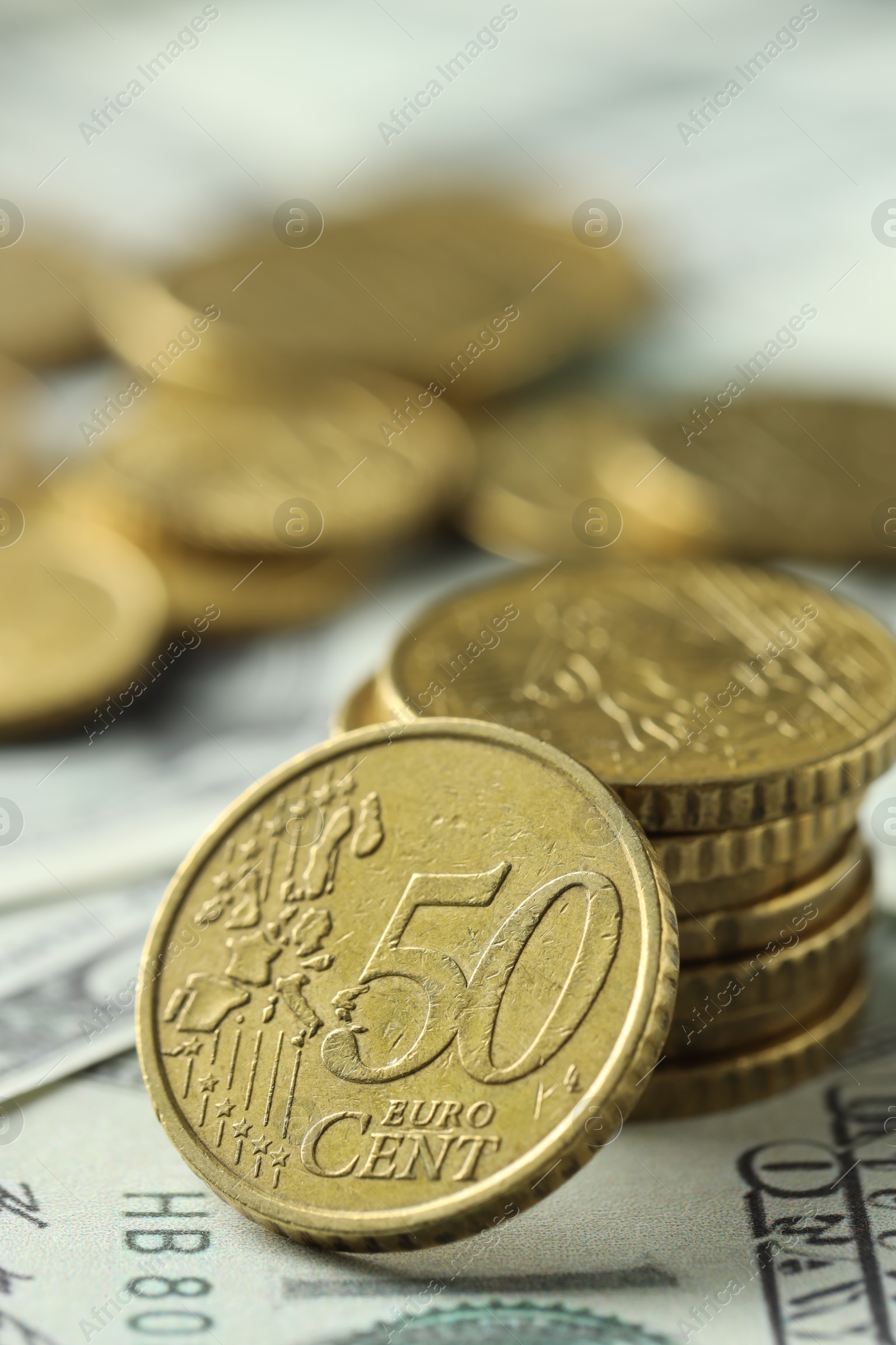 Photo of Many euro coins on dollar banknotes, closeup