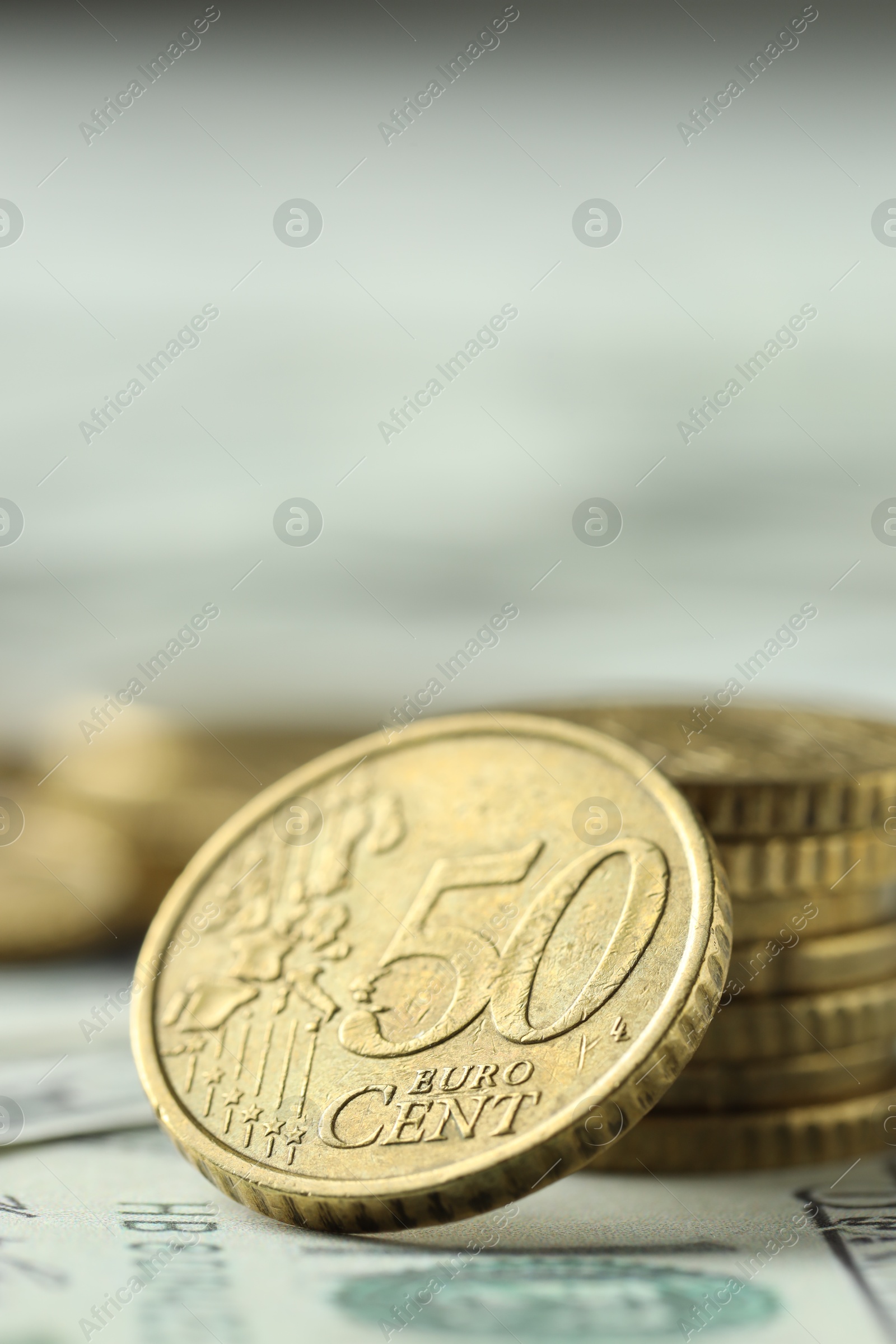 Photo of Many euro coins on dollar banknotes, closeup