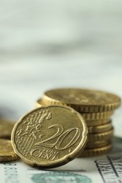 Photo of Many euro coins on dollar banknotes, closeup