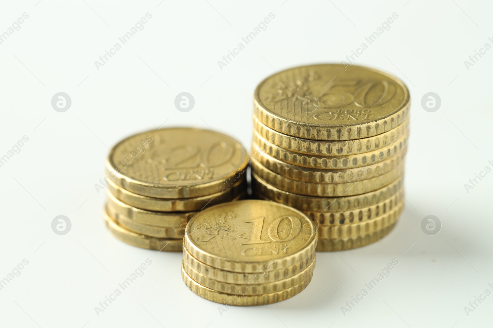 Photo of Stacked euro coins on white background, closeup