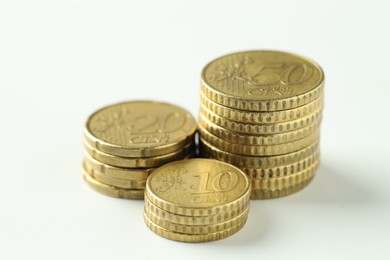 Photo of Stacked euro coins on white background, closeup