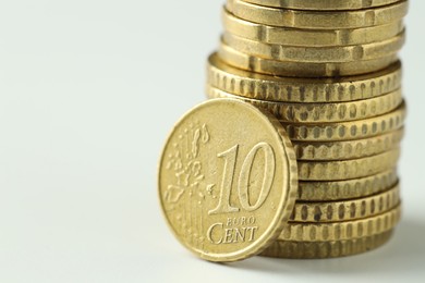 Photo of Stacked euro coins on white background, closeup. Space for text