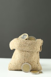 Photo of Euro coins in burlap sack on white table