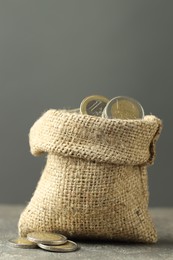 Photo of Euro coins in burlap sack on grey table