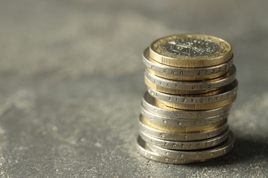 Stacked euro coins on grey table, space for text