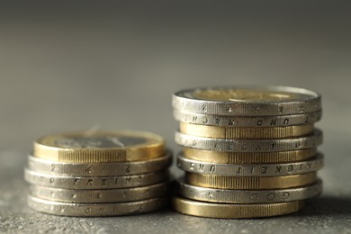 Stacked euro coins on grey table, closeup