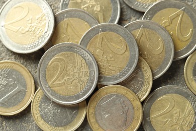 Many euro coins on grey table, top view