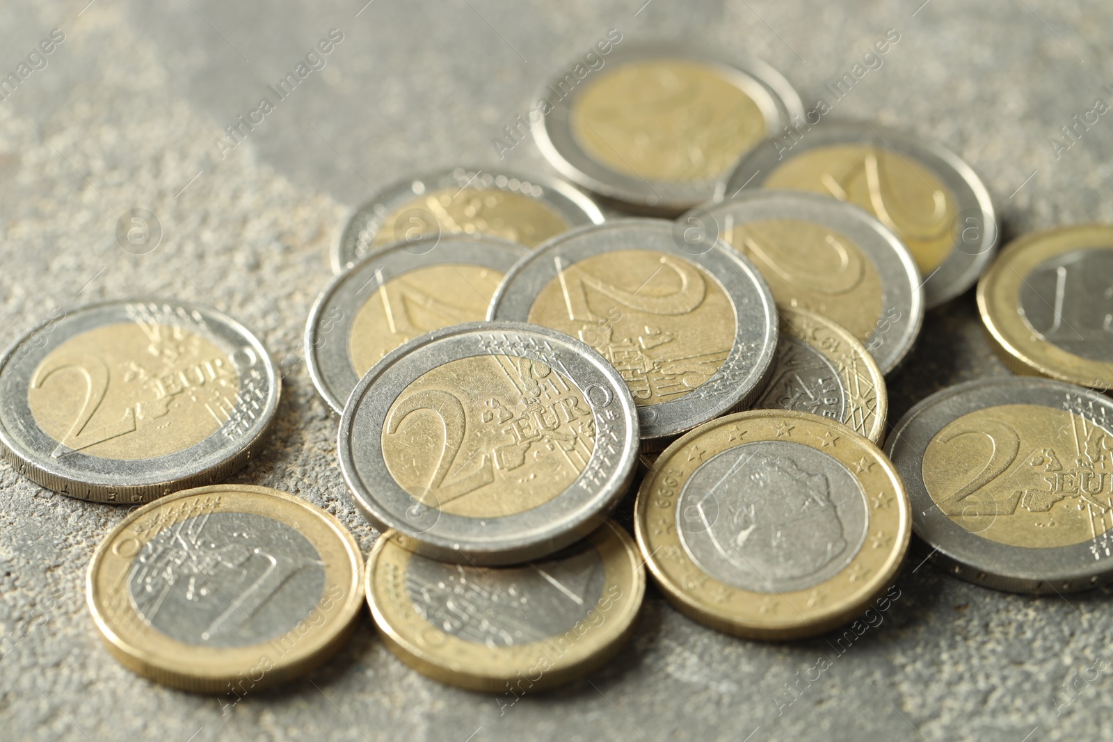 Photo of Many euro coins on grey table, closeup