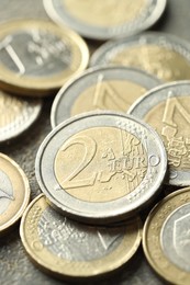 Photo of Many euro coins on grey table, closeup