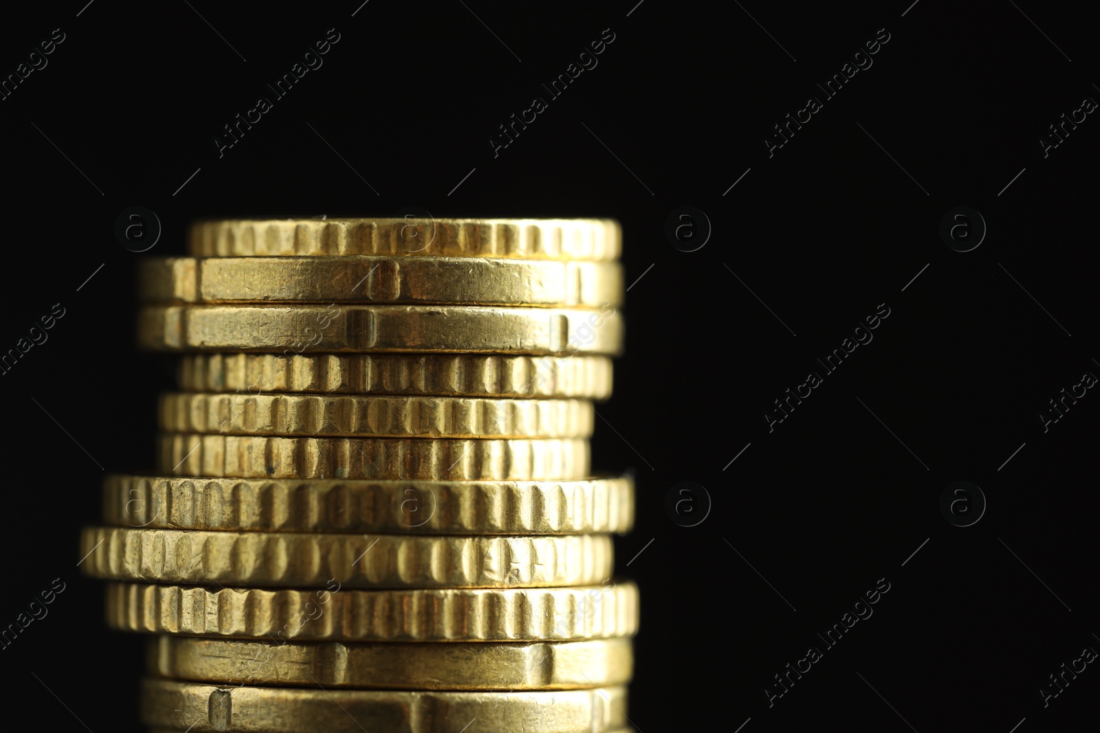 Photo of Stacked euro coins on black background, closeup. Space for text