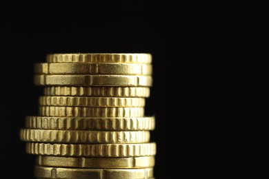 Photo of Stacked euro coins on black background, closeup. Space for text