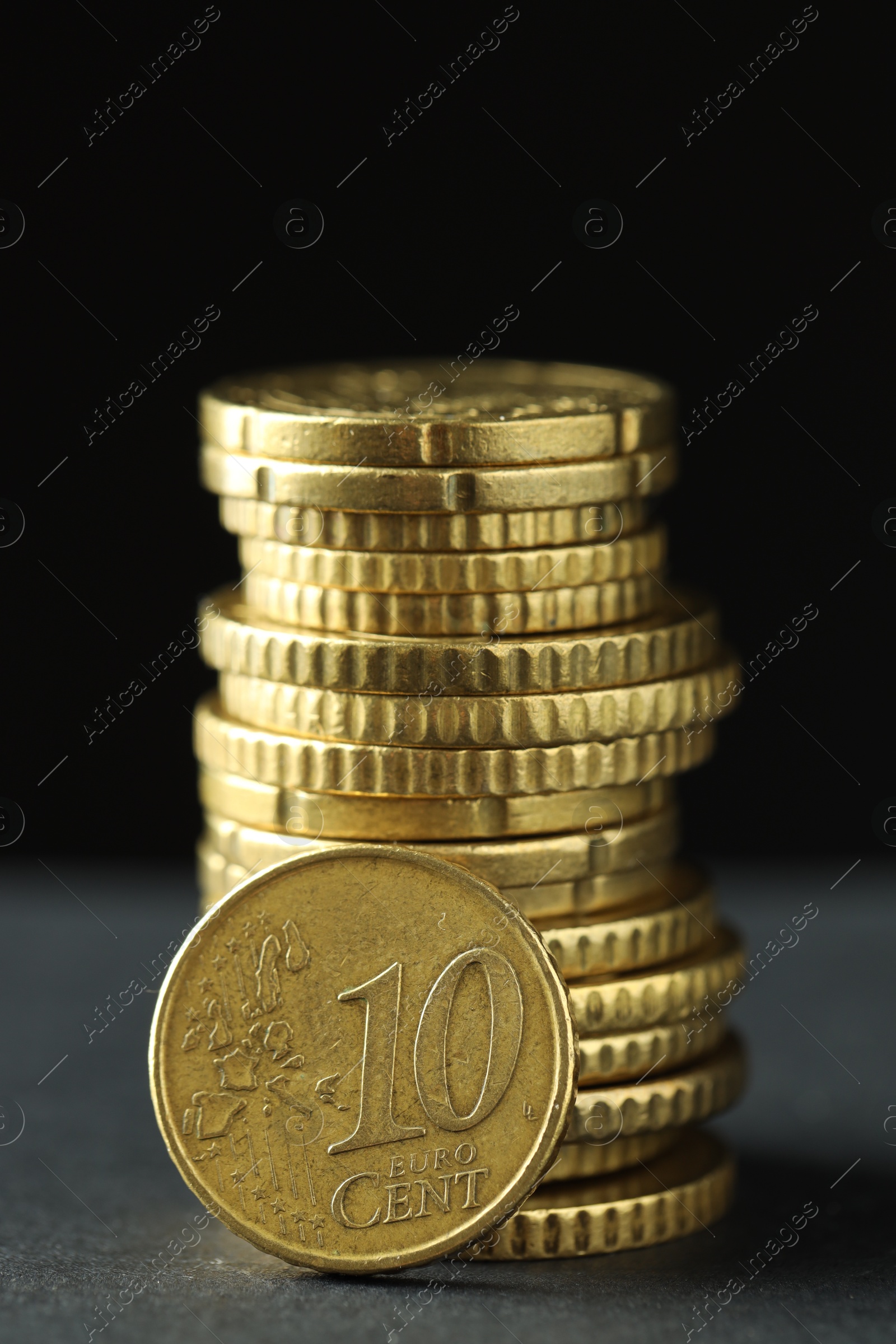 Photo of Stacked euro coins on grey table, closeup