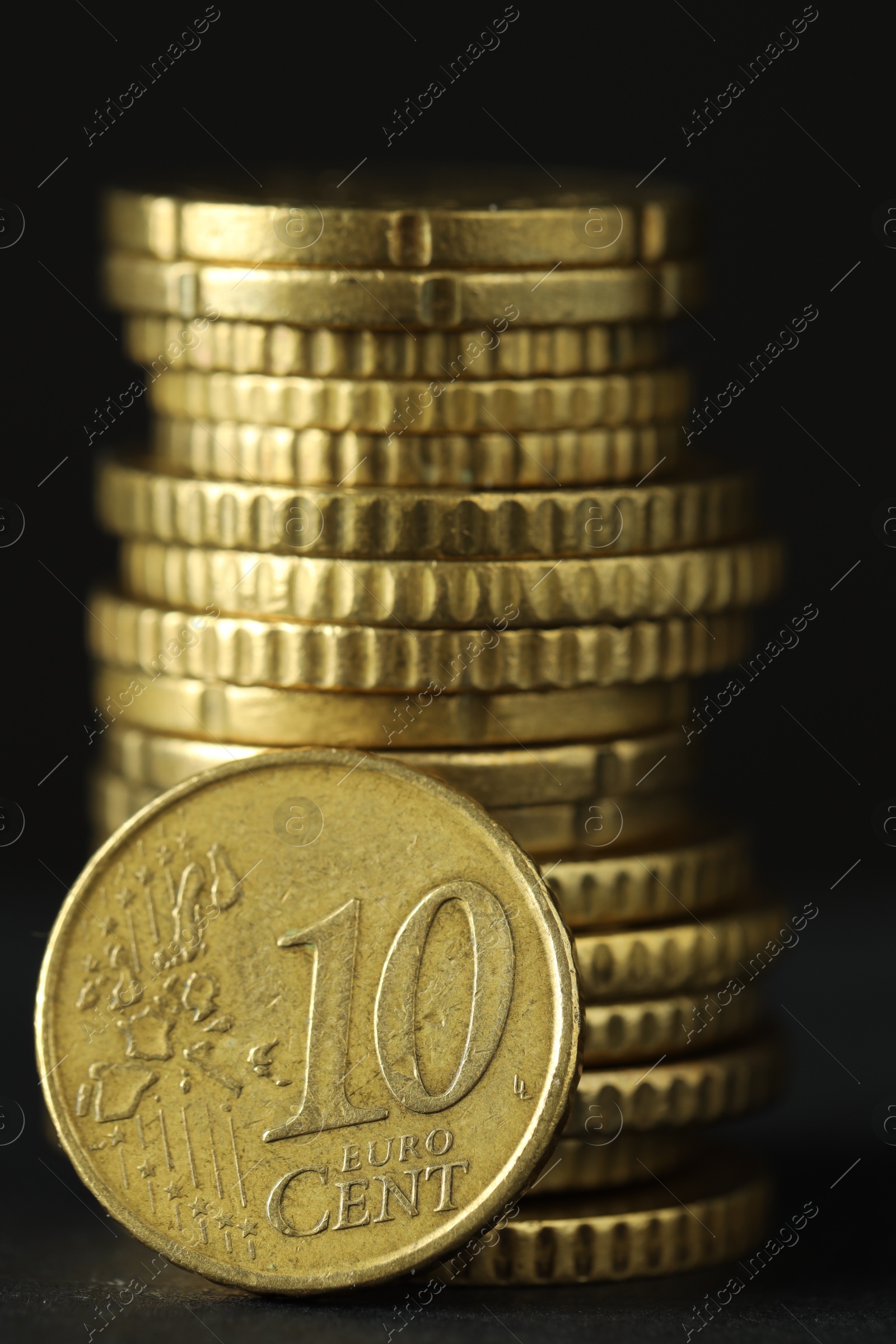 Photo of Stacked euro coins on grey table, closeup