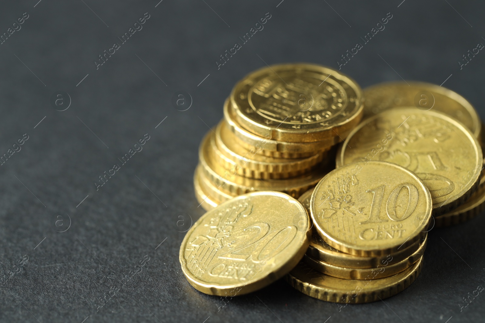 Photo of Many euro coins on grey table, closeup. Space for text