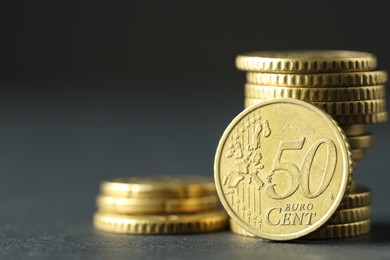 Photo of Stacked euro coins on grey table, closeup