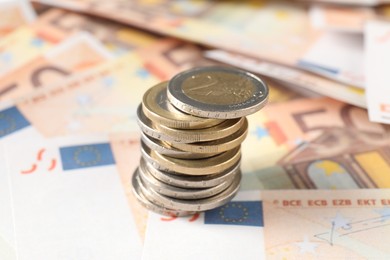 Photo of Stack of coins on euro banknotes, closeup