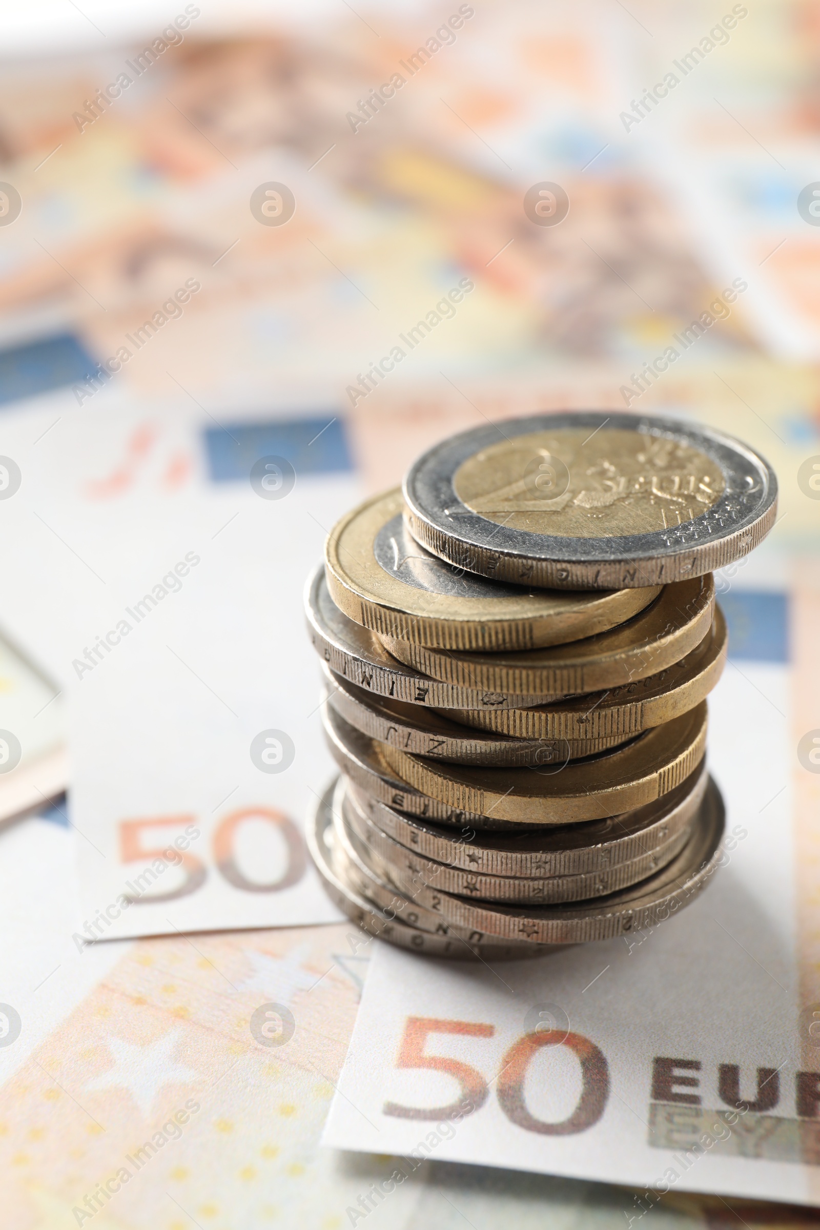 Photo of Stack of coins on euro banknotes, closeup