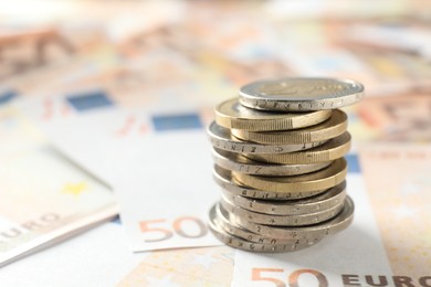 Photo of Stack of coins on euro banknotes, closeup. Space for text