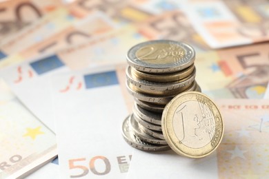 Photo of Stack of coins on euro banknotes, closeup. Space for text