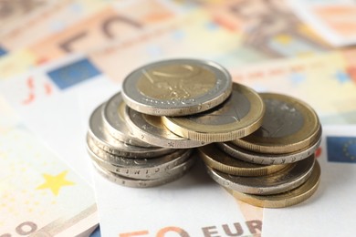 Photo of Many coins on euro banknotes, closeup view