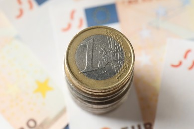 Photo of Stack of coins on euro banknotes, above view