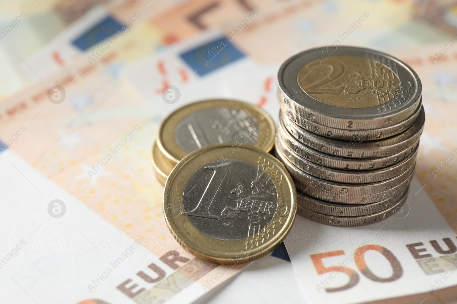 Photo of Many coins on euro banknotes, closeup view