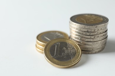 Photo of Stacked euro coins on white background, closeup