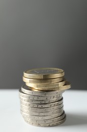 Photo of Stacked euro coins on white table, closeup