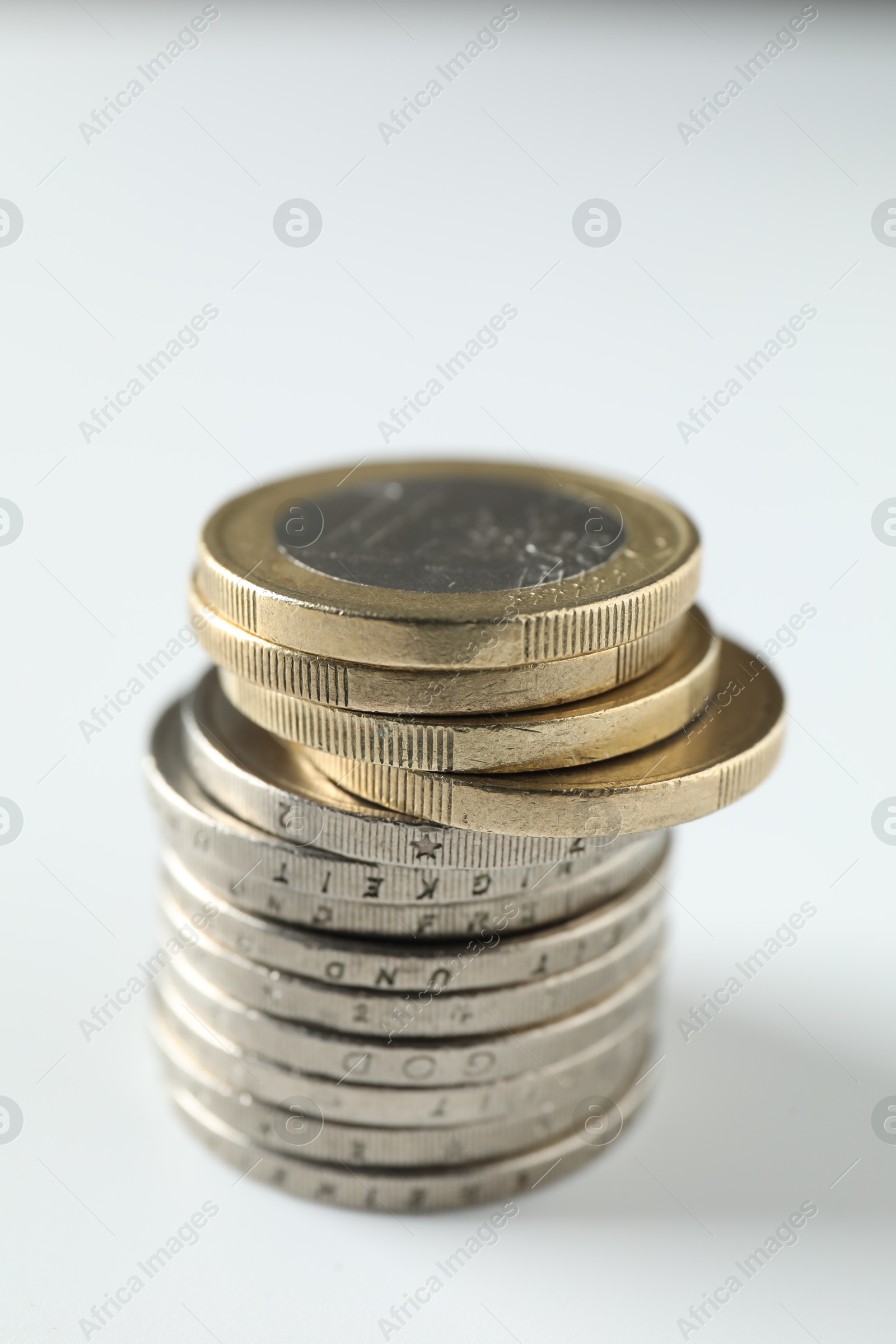 Photo of Stacked euro coins on white background, closeup