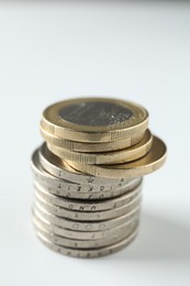 Photo of Stacked euro coins on white background, closeup