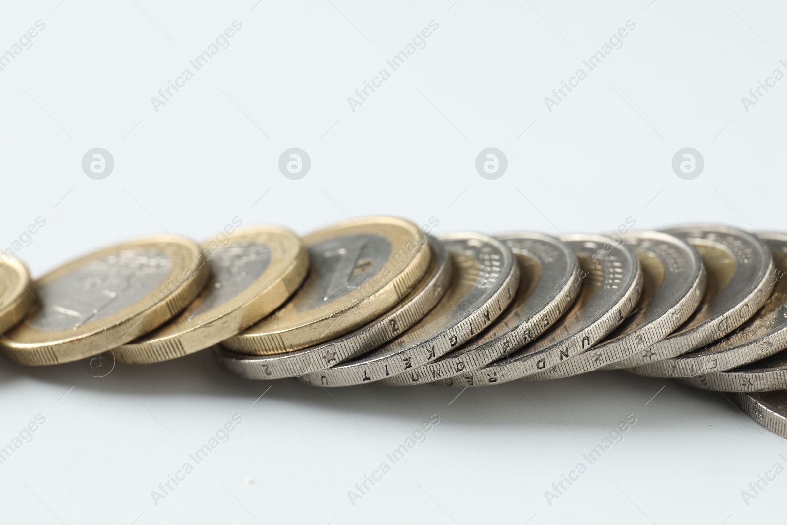 Photo of Many euro coins on white background, closeup