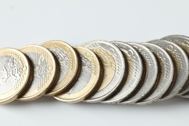 Photo of Many euro coins on white background, closeup