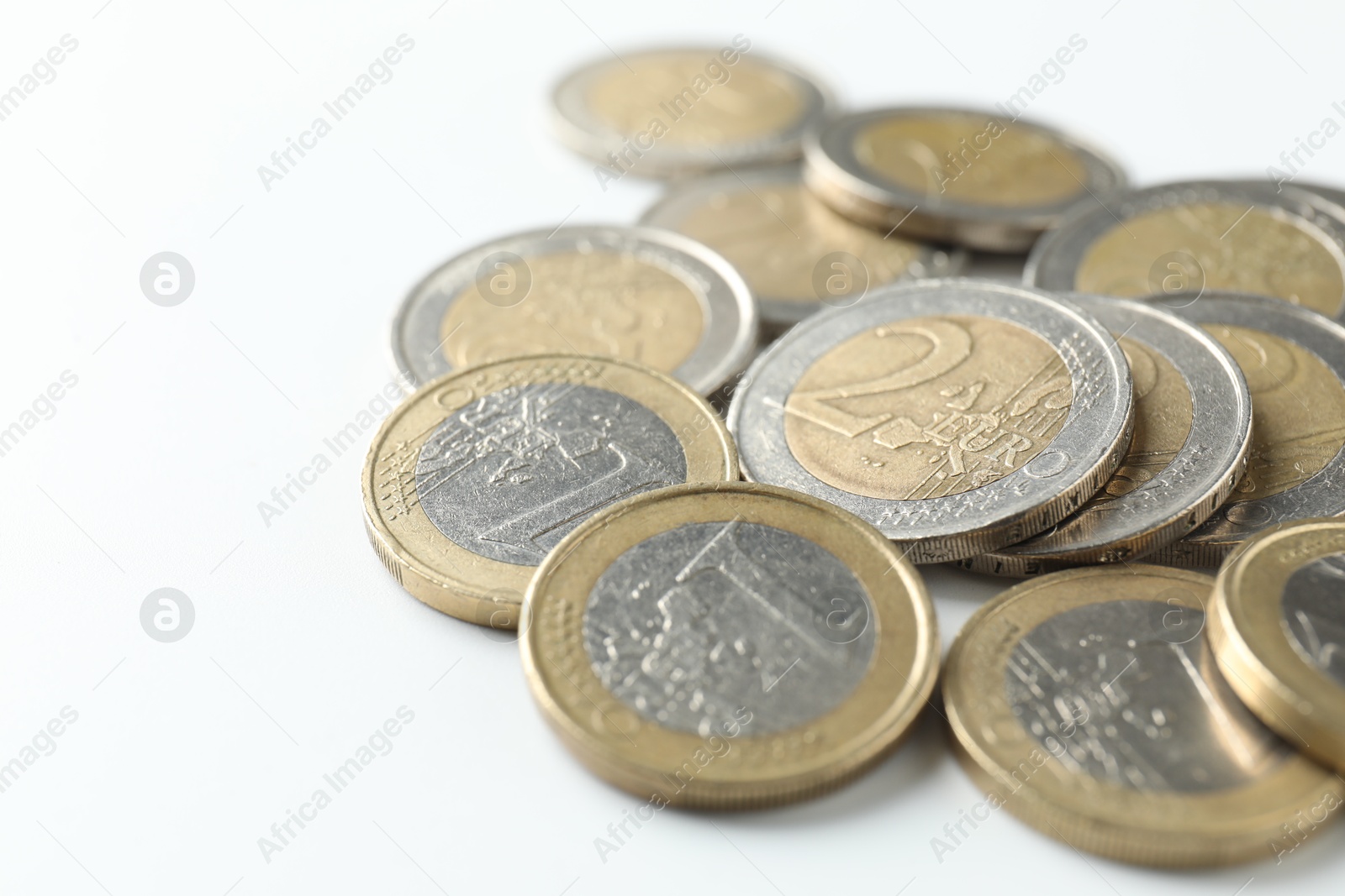 Photo of Many euro coins on white background, closeup