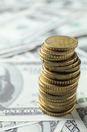 Photo of Stacked euro coins on dollar banknotes, closeup