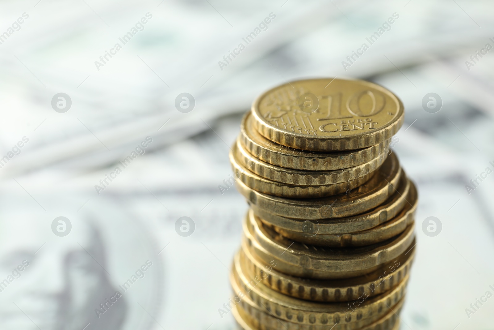 Photo of Stacked euro coins on dollar banknotes, closeup. Space for text