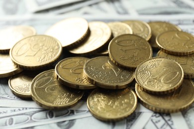 Photo of Many euro coins on dollar banknotes, closeup