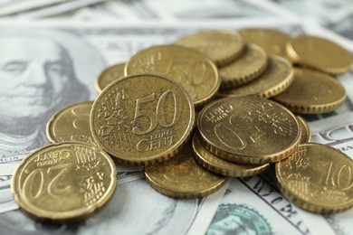 Many euro coins on dollar banknotes, closeup