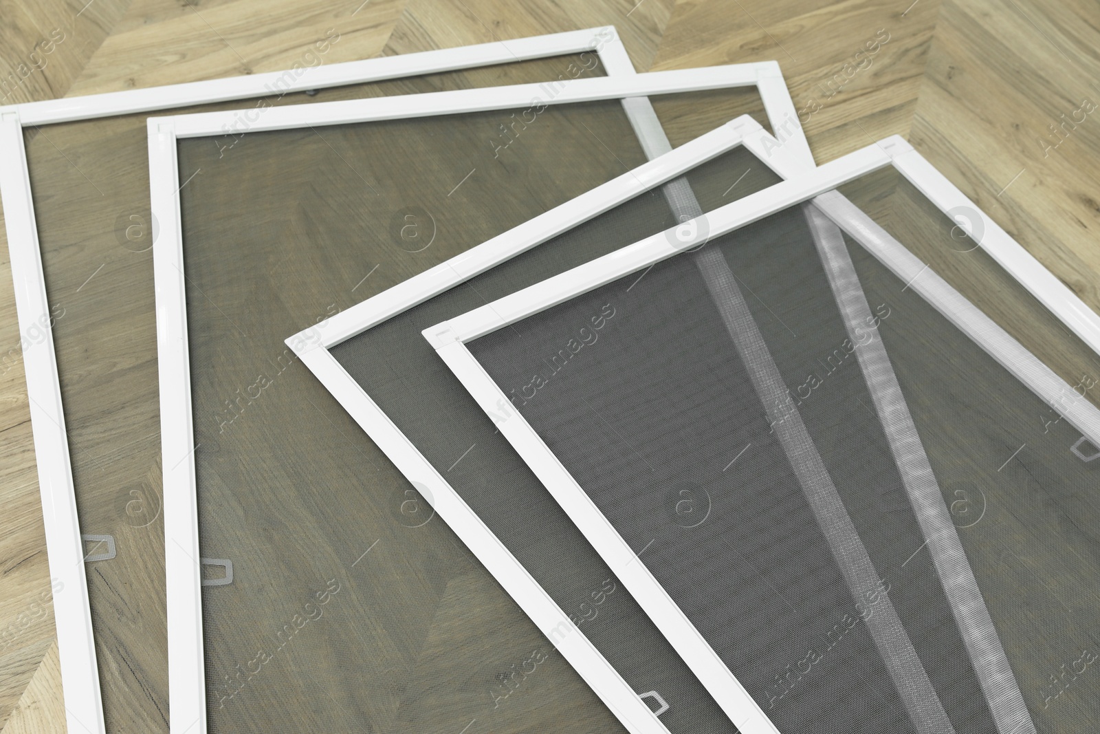 Photo of Set of window screens on wooden floor, above view