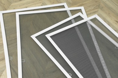 Set of window screens on wooden floor, above view