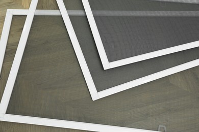 Set of window screens on wooden floor, closeup