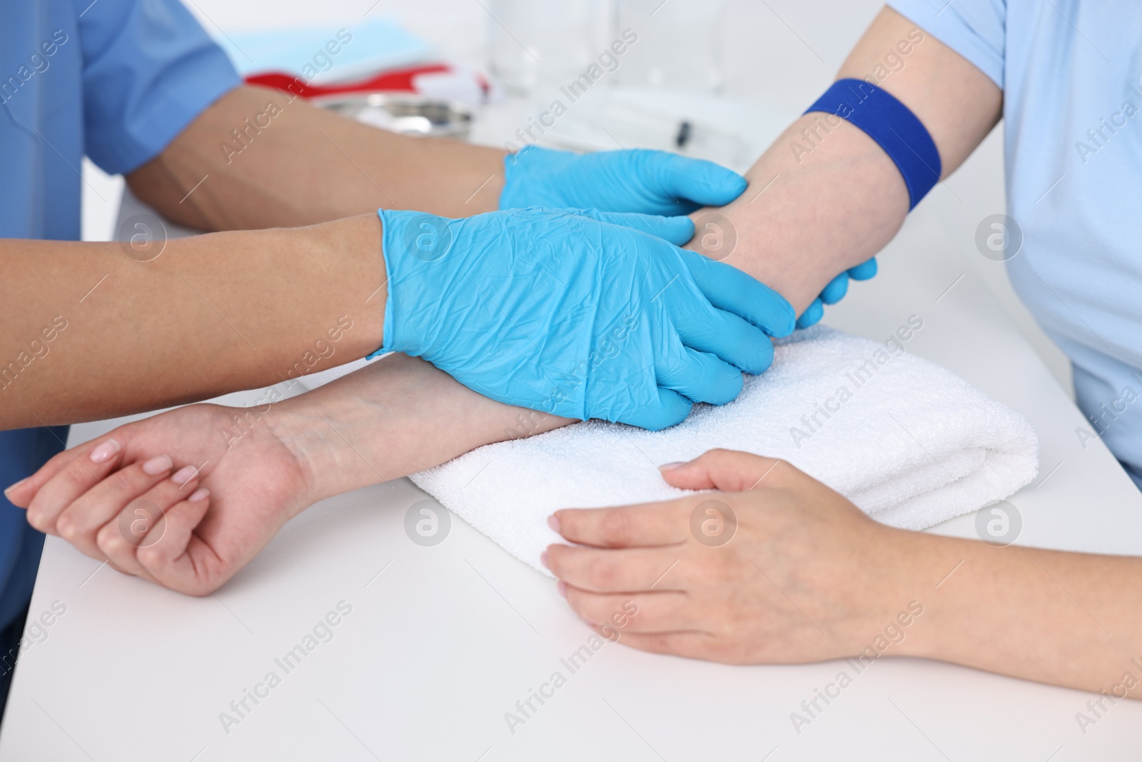 Photo of Nurse inputting catheter for IV drip in patient hand, closeup