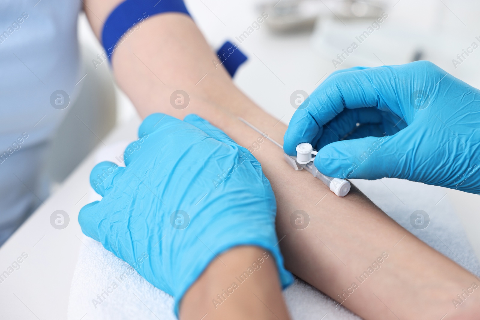 Photo of Nurse inputting catheter for IV drip in patient hand, closeup