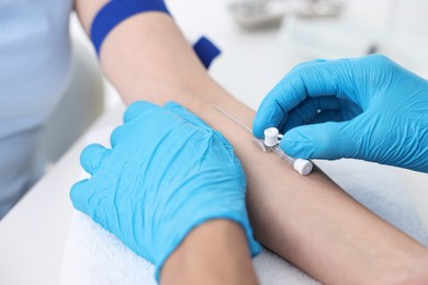 Nurse inputting catheter for IV drip in patient hand, closeup