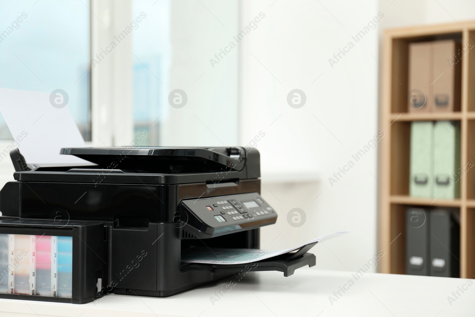 Photo of Modern printer with paper on white table in office