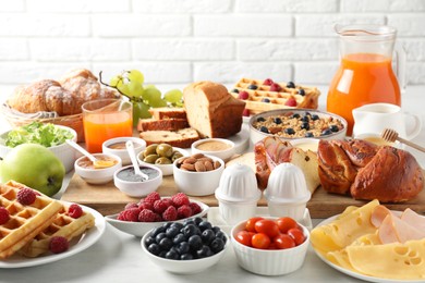 Different meals served for breakfast on white table