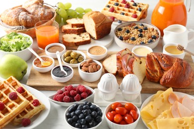 Photo of Different meals served for breakfast on white table