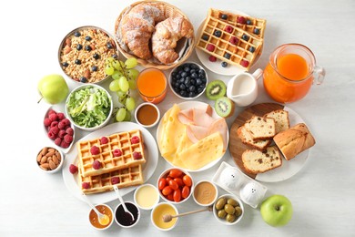 Photo of Different meals served for breakfast on white table, flat lay