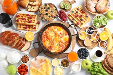 Photo of Different meals served for breakfast on white table, flat lay