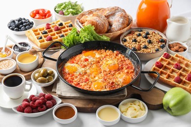 Photo of Different meals served for breakfast on white table