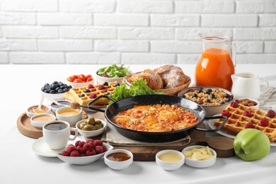 Different meals served for breakfast on white table